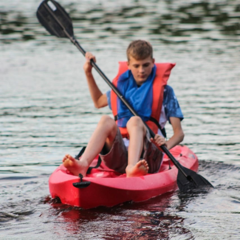 boy paddling in lake